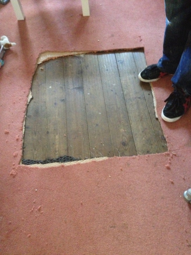 Just cut a hole in the carpet, it's coming up anyway. Floor sanding guy looks in disbelief then asks for a knife.